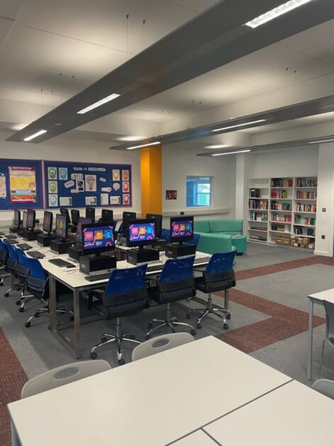 a library with computers and tables in it - SBUSixth